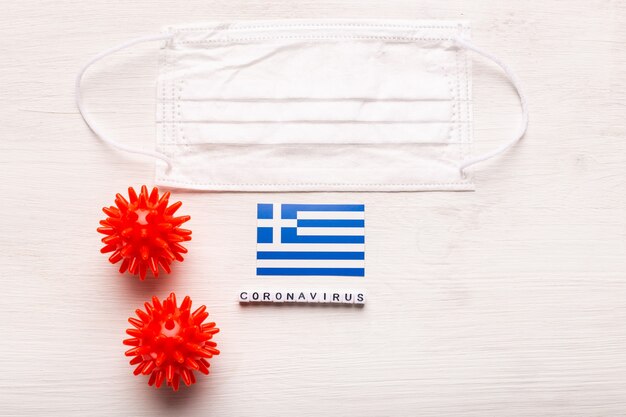 Coronavirus covid concept top view protective breathing mask and flag of greece