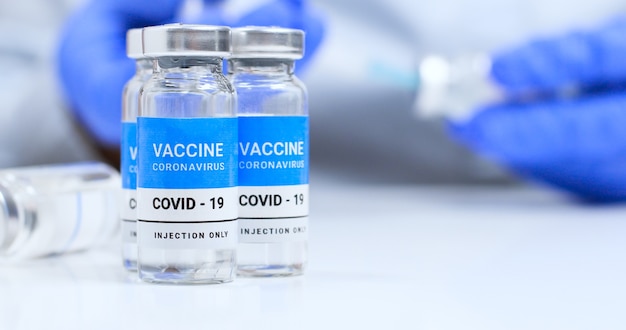 Coronavirus covid experimentele vaccinflesjes op een witte plaat