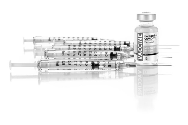 Photo coronavirus covid19 vaccine vial and several syringes on reflective surface