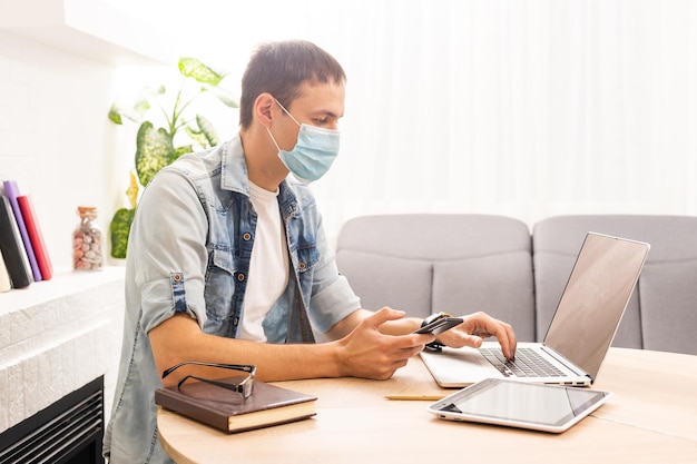 Coronavirus en Coronacrisis. Gestresste man op laptop die tempels masseert met zakelijke problemen om thuis te zitten. Selectieve focus