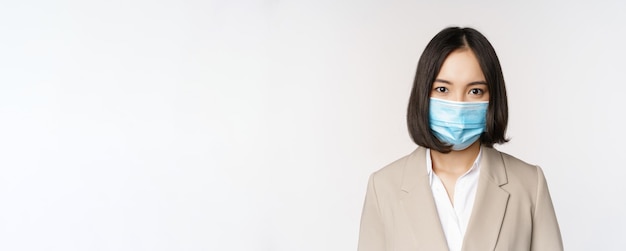 Coronavirus en werkplekconcept portret van Aziatische kantoormedewerker zakenvrouw met medisch gezichtsmasker