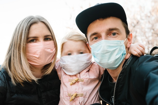 Photo coronavirus the end concept, virus disease. healthy family with child in medical protective mask in the street. health protection and prevention during flu and infectious outbreak. no more covid-19.