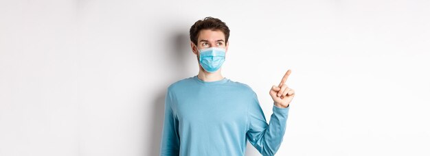 コロナウイルスの健康と検疫のコンセプト 医療マスクを着た男が笑顔で見て喜んでいる