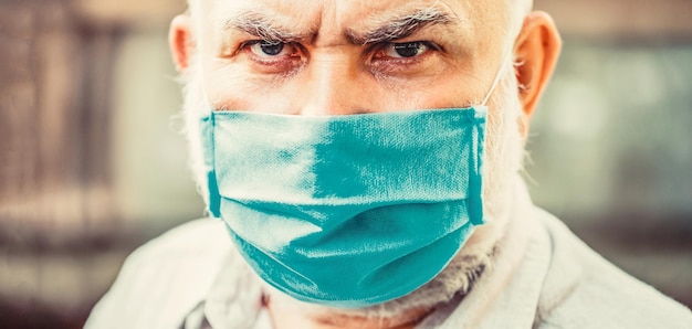 Coronavirus illness infection quarantine medical mask Old man wearing face mask Closeup