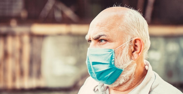 Coronavirus, illness, infection, quarantine, medical mask. Old man wearing face mask. Portrait of an old man, years old, in a medical mask. Concept danger of coronavirus for the elderly.