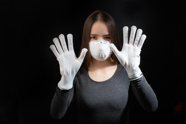 Coronavirus Jonge vrouw met zwart antibacterieel medisch masker en beschermende handschoenen zwarte achtergrond