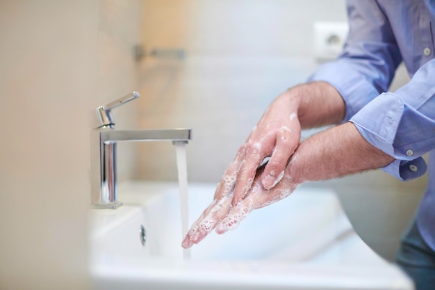 Coronavirus male wahing hands in bathroom