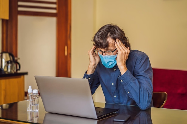 Coronavirus Man working from home wearing protective mask quarantine for coronavirus wearing protective mask Working from home