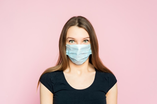 Photo coronavirus, masked woman.studio portrait of a young woman wearing a face mask