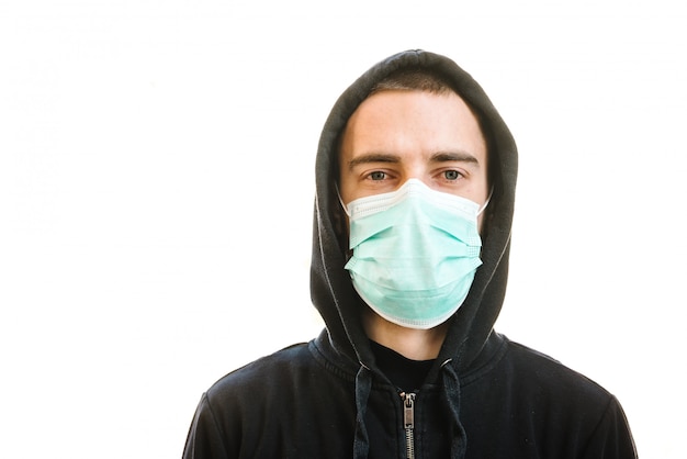 Coronavirus. Mens die medisch beschermend masker op een witte muur draagt. Voorkom Covid-19, griep. Virus, pandemie, paniek concept. Bescherm je gezondheid. Concept van quarantaine. Ruimte voor tekst.