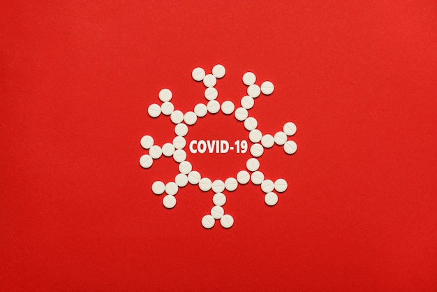 Coronavirus microscope structure concept. Top overhead flat lay photo of coronavirus made of small white round pills isolated over red background with copy empty blank space