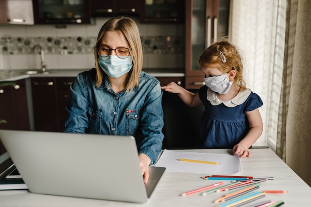 コロナウイルス。ママと娘が検疫で保護マスクを着用しています。