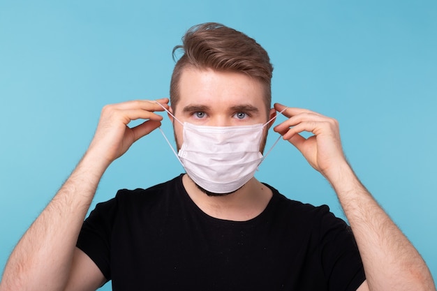 Coronavirus outbreak covid and pandemic concept. Man putting on a medical disposable mask