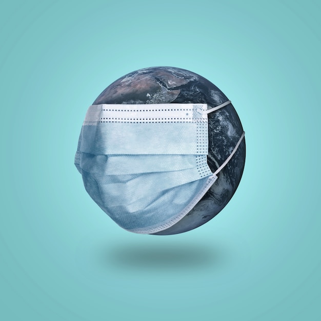 coronavirus pandemic covid-19 concept. planet earth in a medical protective mask on a blue.