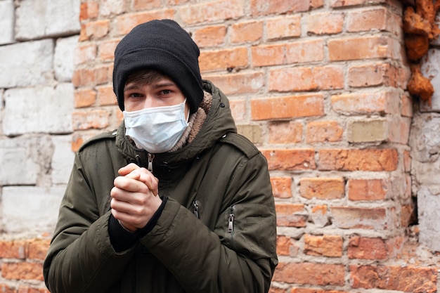 Coronavirus pandemic .sick guy in a medical mask on a wall background. viral outbreak epidemic covid-19.