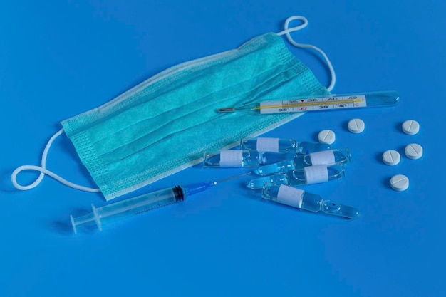 Coronavirus personal protective equipment disposable medical mask drugs with a syringe vaccine and pills Medicines for the virus and flu Antibiotics
