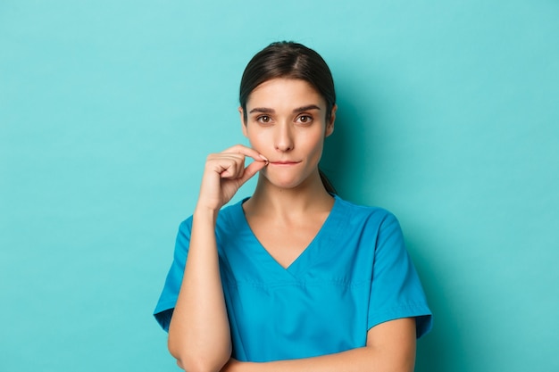 Coronavirus, social distancing and health concept. Close-up of woman doctor in scrubs, making