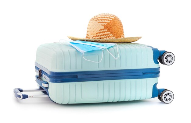 Photo coronavirus tourism concept with white medical face mask on blue luggage for traveling by train