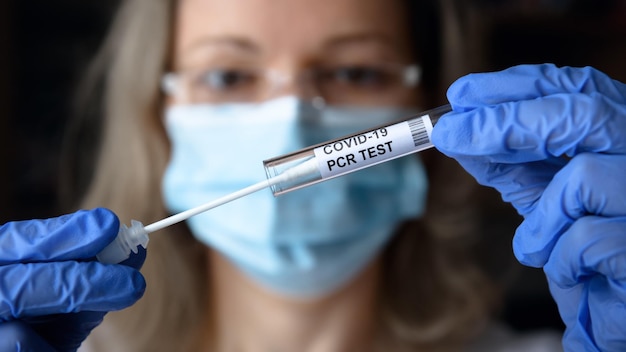 Coronavirus-uitstrijkjesverzamelingsset van PCR-test in handen van een arts