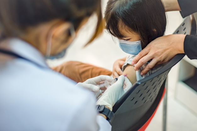 Vaccinazione contro il coronavirus. vaccino contro il covid19. medico che vaccina gli scolari a scuola per prevenire una grave epidemia tra gli scolari. ragazzino che si fa vaccinare contro l'influenza. prevenzione del virus.