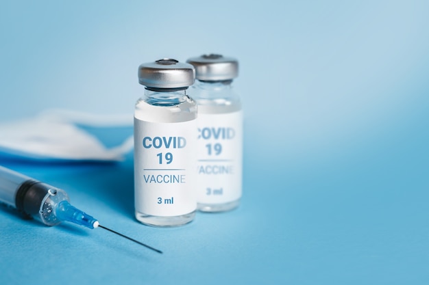 Coronavirus vaccine. Ampoules with coronavirus vaccine and a syringe. Covid-19 treatment. Copy space