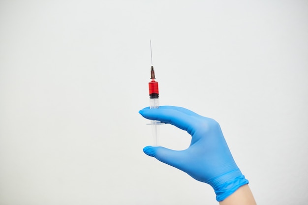 Coronavirus vaccine, vaccination of the population against the disease, fighting the epidemic, hands in medical gloves holding a syringe with medicine