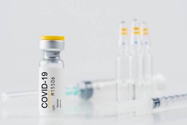 Coronavirus vaccine vial glass with a syringe on white background