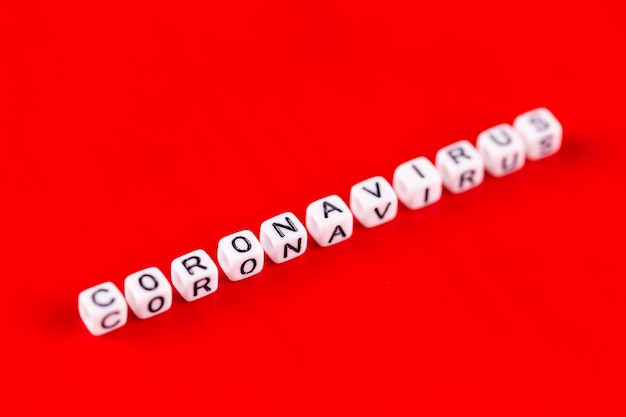 Coronavirus word made of white blocks. Coronavirus text on red background.
