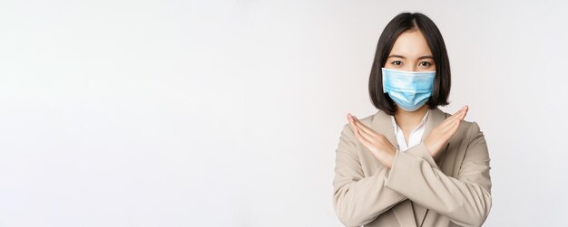 Coronavirus and workplace concept image of asian businesswoman female in medical face mask shows sto