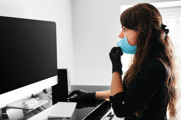Coronavirus. Young business woman working from home wearing protective mask. Business woman in quarantine for coronavirus wearing protective mask. Working from home
