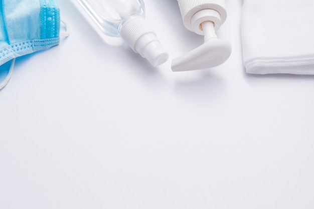 Coronavirusbescherming op een witte achtergrond. Vloeibare zeep, desinfector, medisch masker, servetten - viruscontroleconcept
