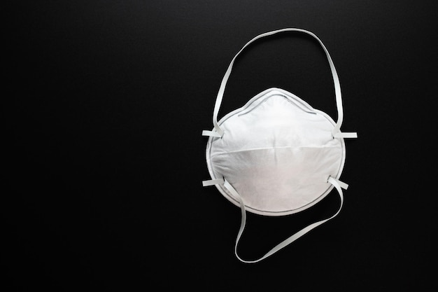 Coronavirusbescherming Wit antibacterieel medisch masker op een zwarte achtergrond