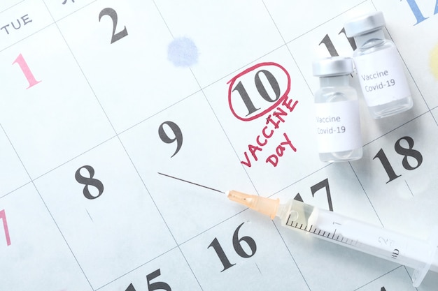 Coronavirusvaccin en spuit op kalender.