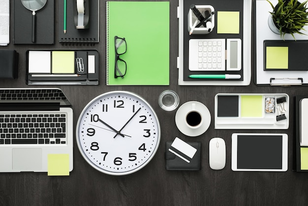 Corporate business desktop with laptop office accessories and a clock business productivity and deadlines concept