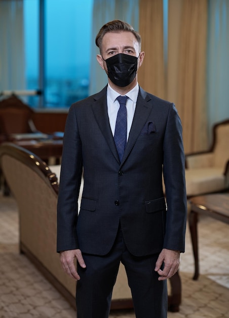 Фото Корпоративный деловой человек в защитной медицинской маске в роскошном офисе