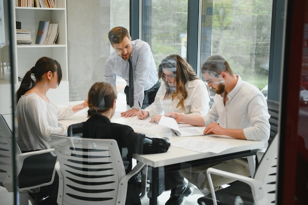 Team aziendale e in una riunione in un ufficio moderno con grandi finestre foto di alta qualità