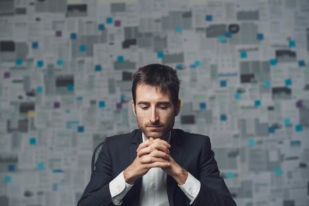 Corporate businessman thinking with hands clasped he needs a solution for his business