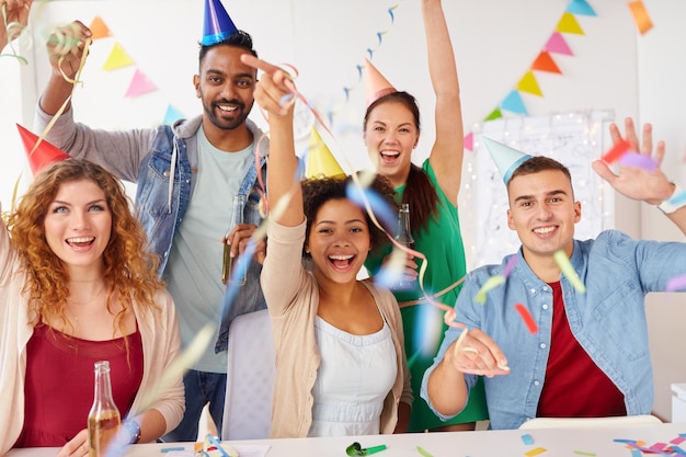 Foto celebrazione aziendale e vacanze concetto squadra felice con confetti e serpentine divertirsi alla festa d'ufficio