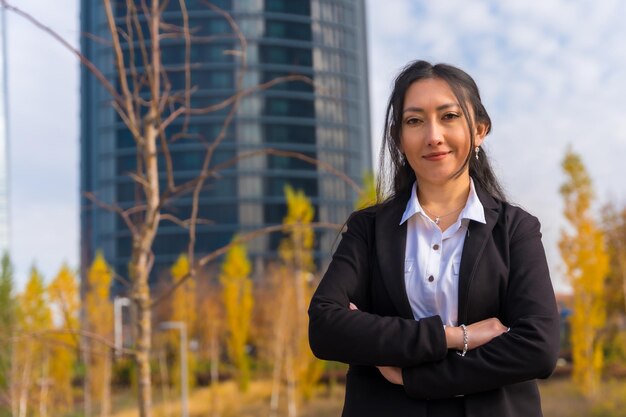 Corporate portrait of latin businesswoman business park arms crossed