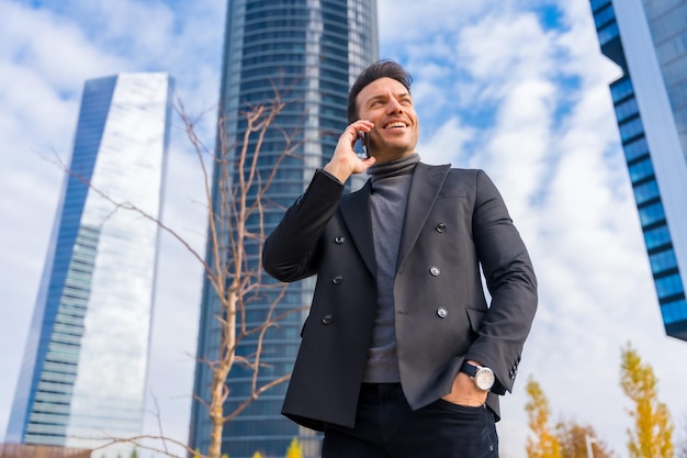 Corporate portrait of middleaged businessman talking on the phone next to skyscraper office