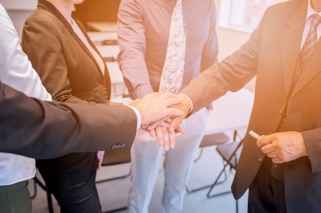 Corporate team stacking each other's hand in the office