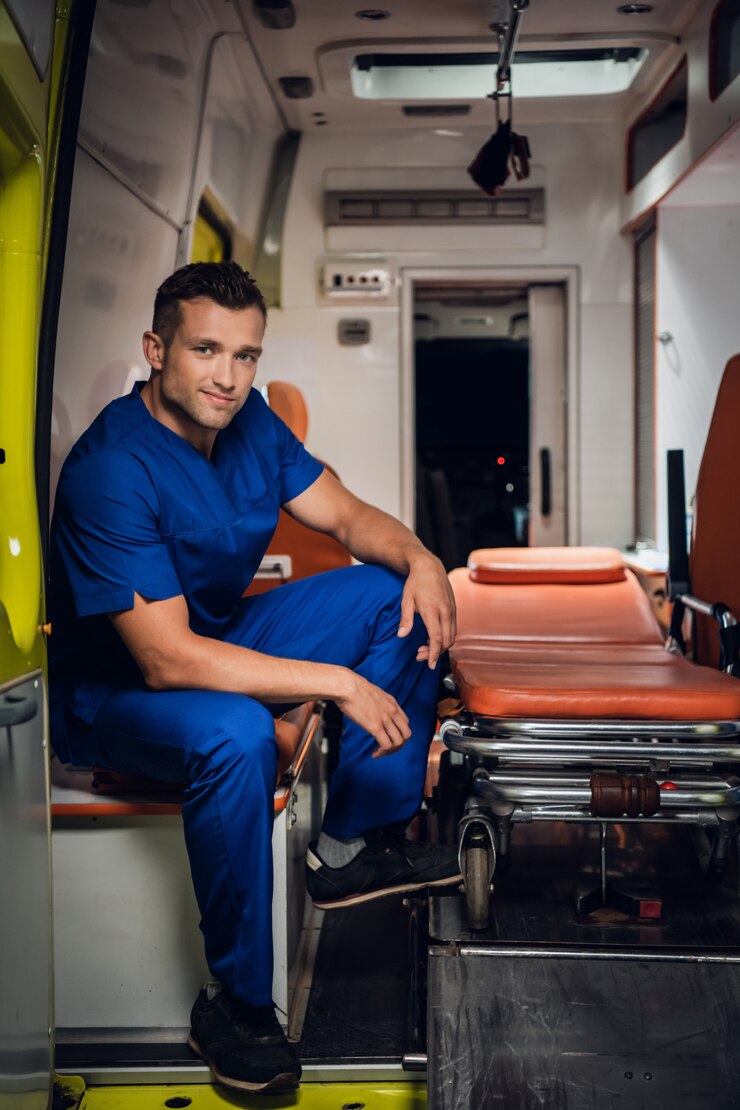 Corpsman in een blauwe uniform zitten in een ambulance auto glimlachen