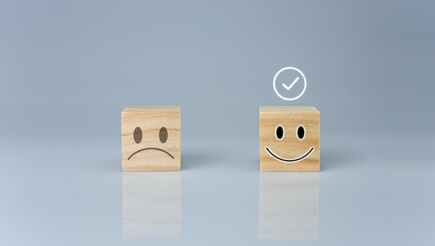 Foto il segno corretto è su un blocco di legno con un'icona sorridente. rappresenta la valutazione del feedback.