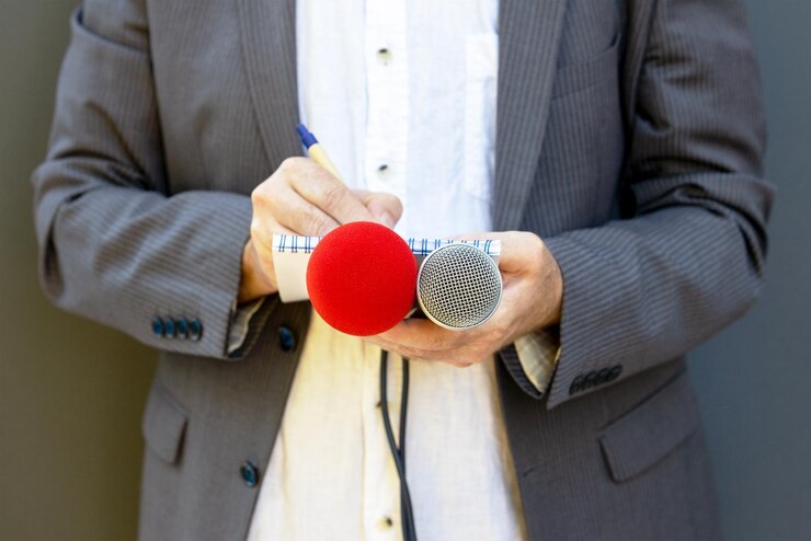 Photo correspondent or reporter at media event holding microphone writing notes journalism concept