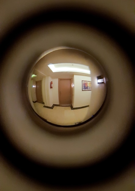 廊下、燃えるランプ、床、2つの隣接するドアがドアののぞき穴に見えます