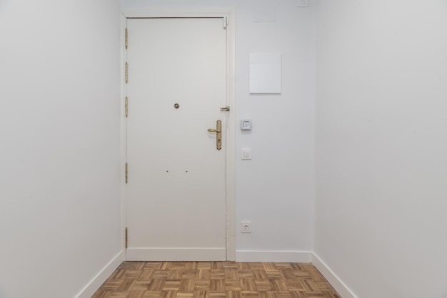 Corridor of a house with white wooden armored door with freshly painted smooth white