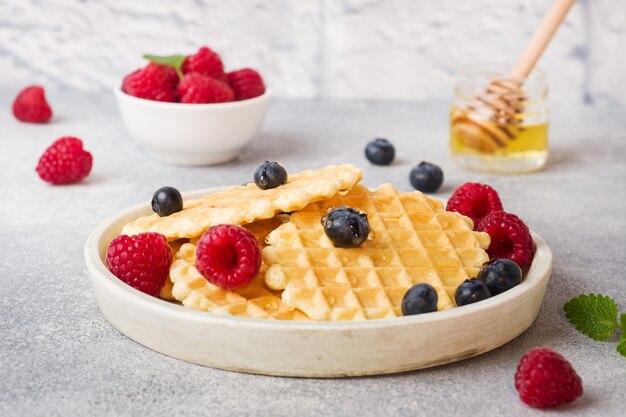 Corrugated waffle cookies with fresh raspberries and blueberries 