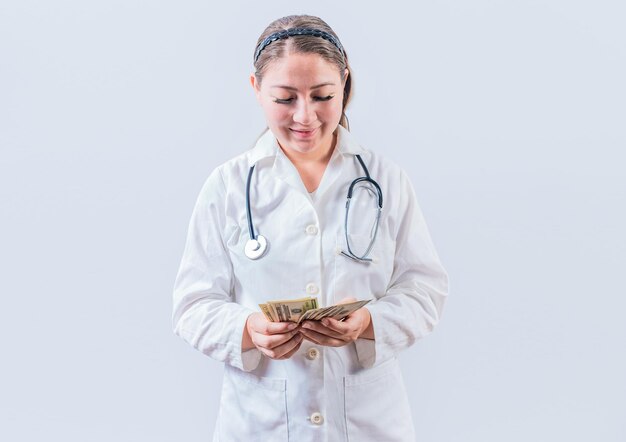 分離されたお金を数える腐敗した女性医師 白い背景の上の紙幣を数える女性医師 医療汚職の概念