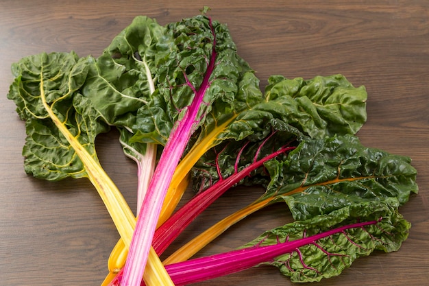 Corsage of chard leaves that has stems in yellow pink and red colors