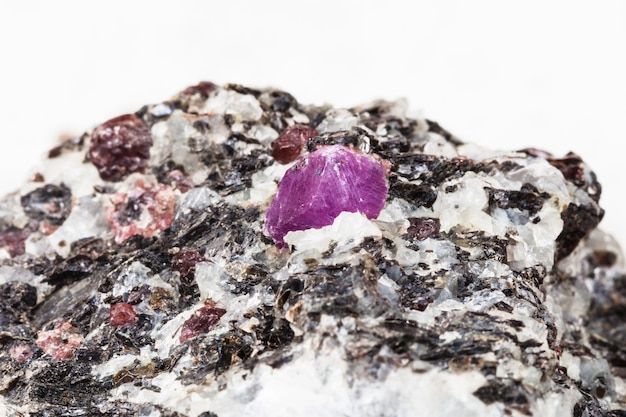 Corundum crystal in gneiss stone close up on white
